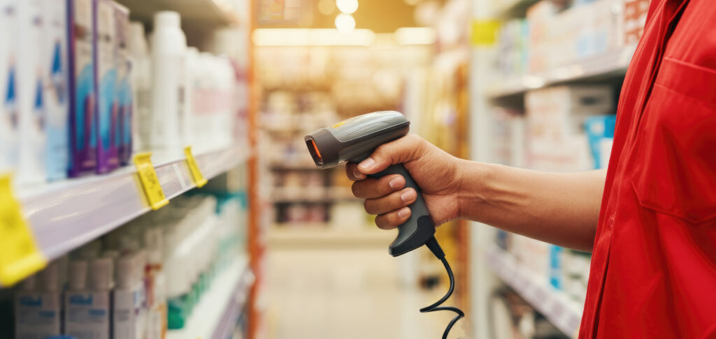 hand holding barcode scanner in store aisle, scanning products